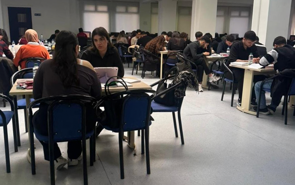Students studying together in a campus study hall during a group work session.