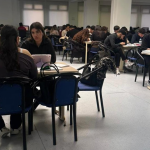 Students studying together in a campus study hall during a group work session.